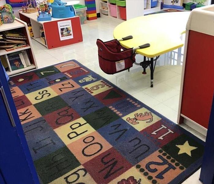 preschool with alphabet carpet and standing water in the room