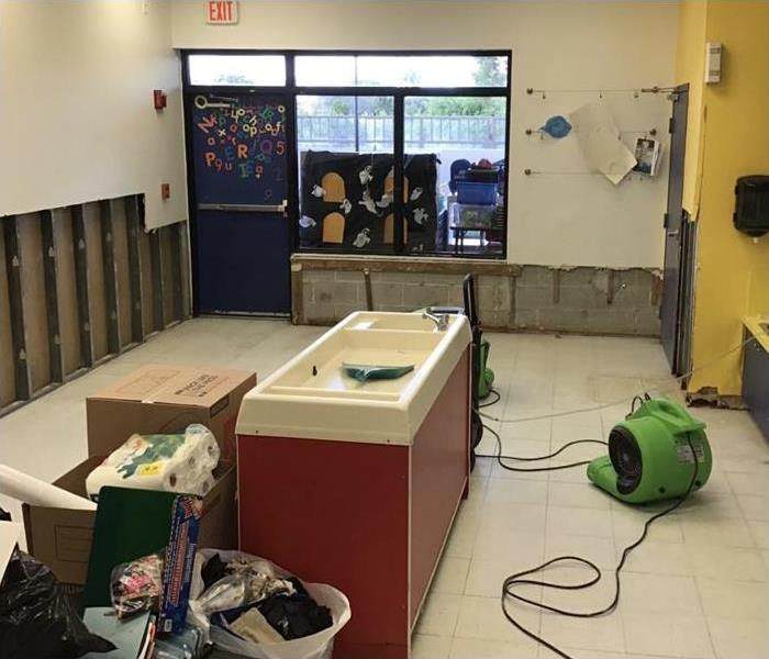 drywall removed in a pre-school room and drying equipment placed on area.